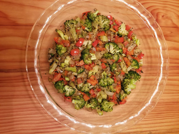 Add the saute'd vegetables to an oiled pie pan
